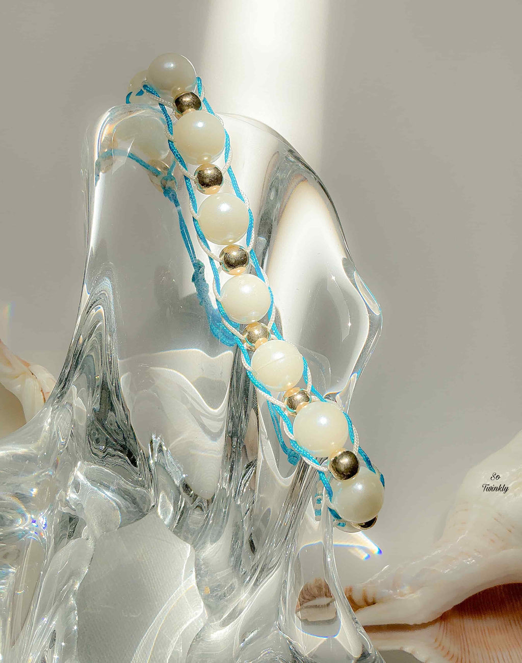 Handmade blue and white bracelet with gold and white acrylic pearls on soft adjustable nylon cord