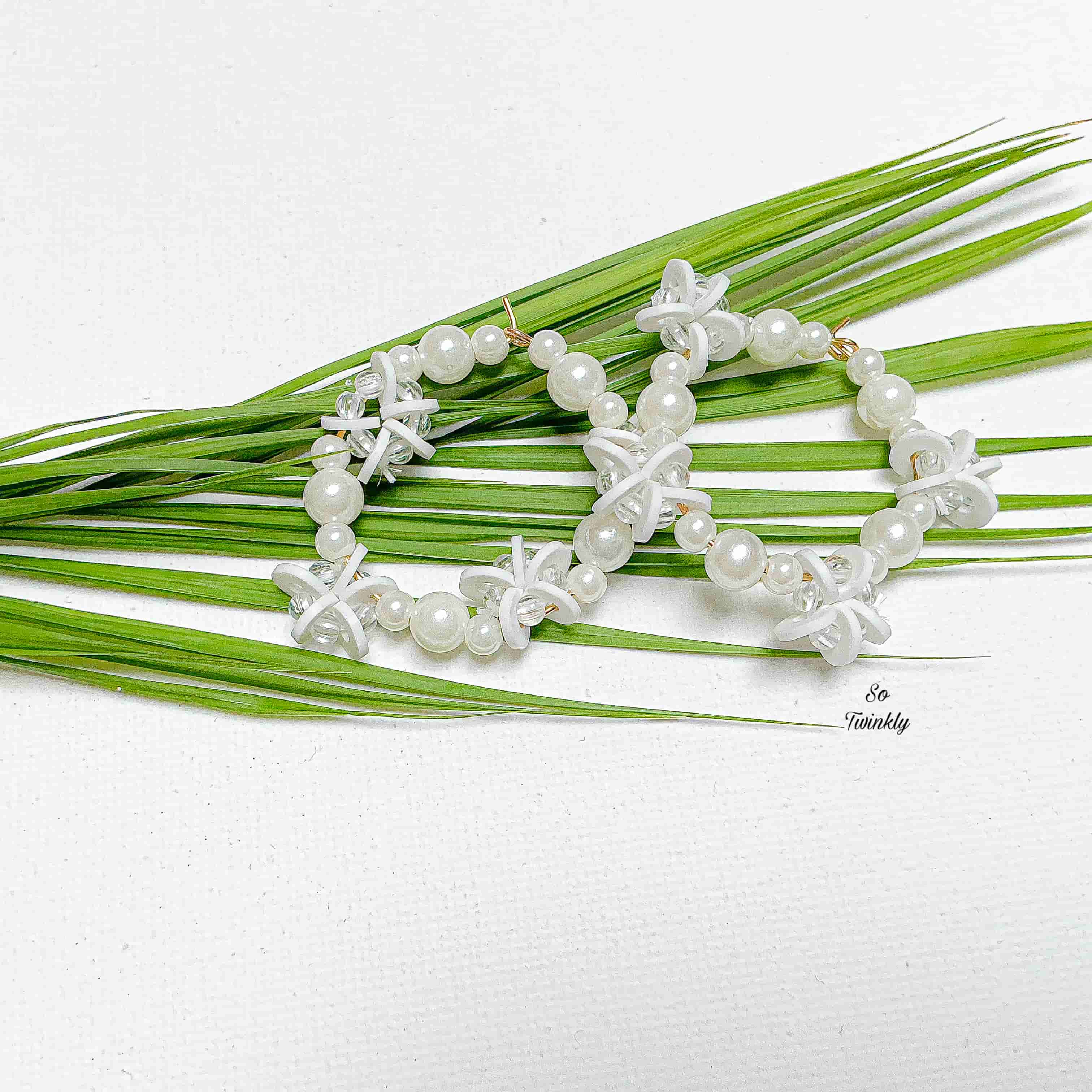 Handmade earrings with white acrylic pearls and star-shaped polymer clay beads on hypoallergenic hooks