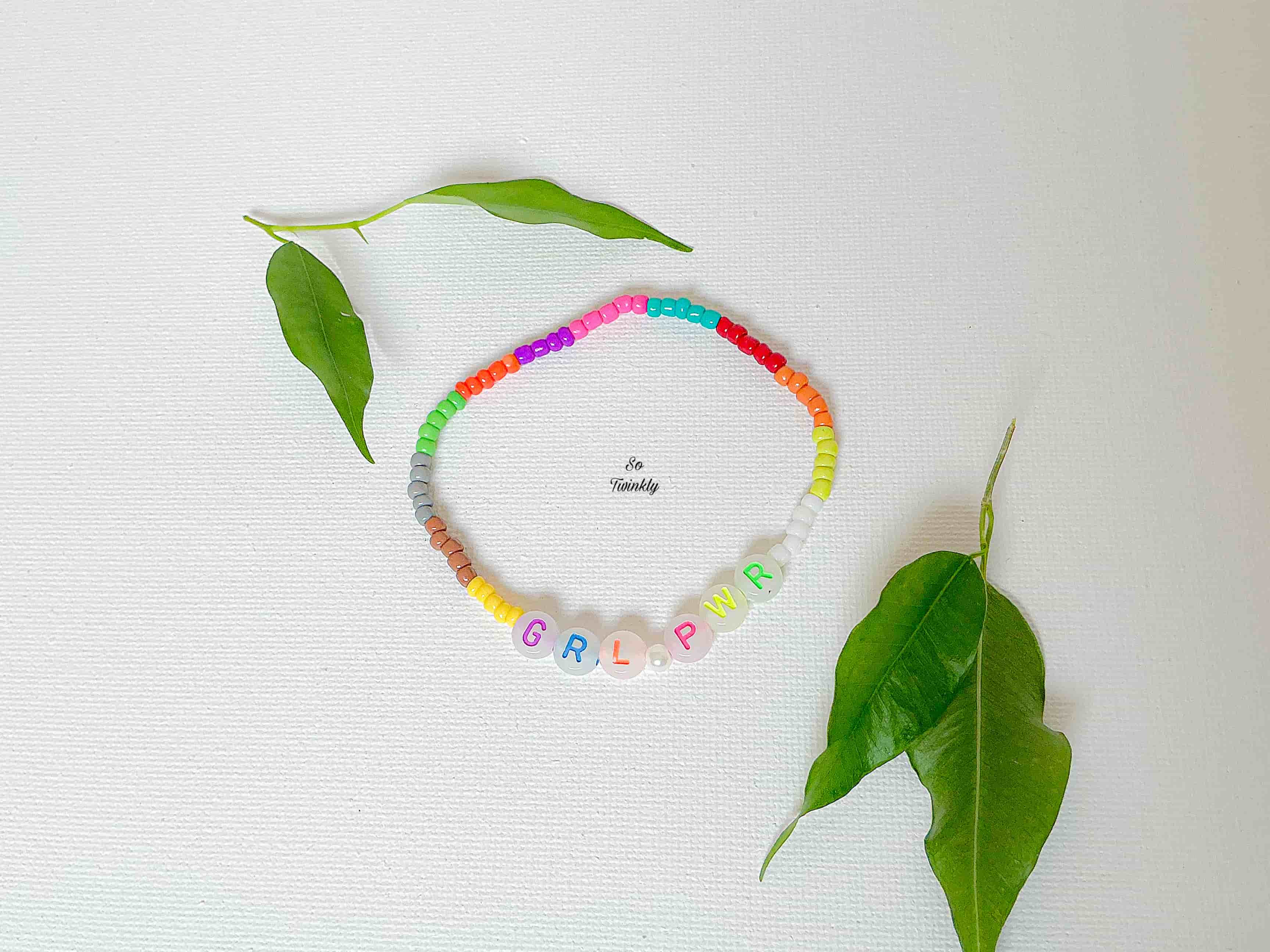 Handmade bracelet with multicolor acrylic beads and a bold central message charm that reads “GIRL POWER”