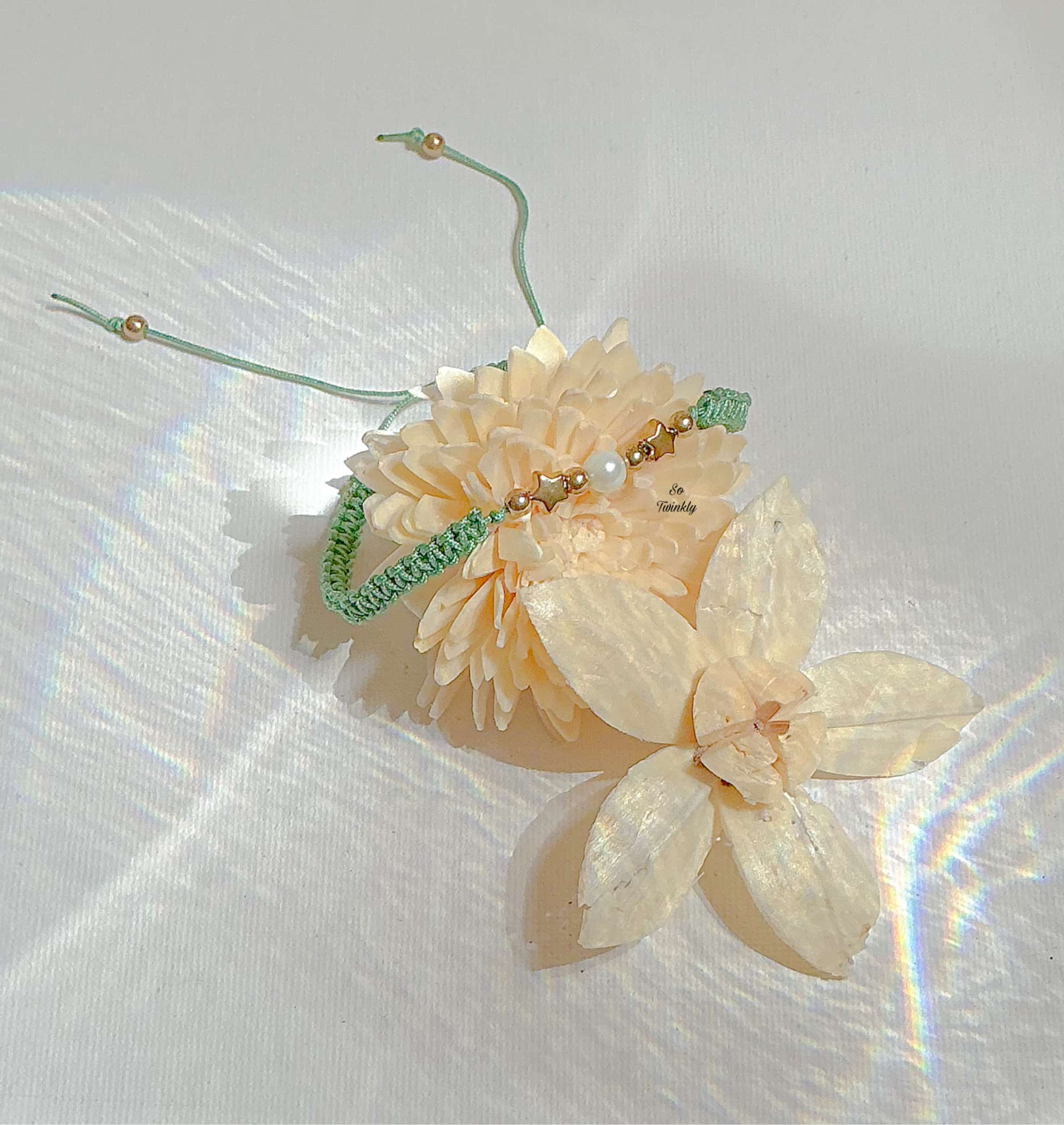 Handmade celestial bracelet with moon-like white pearl, two gold star charms, and adjustable nylon cord