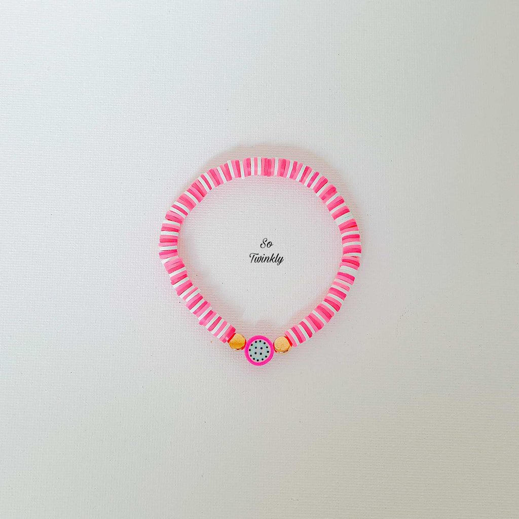 Flat lay of pink melon bracelet featuring gold acrylic pearls and vibrant polymer clay beads

