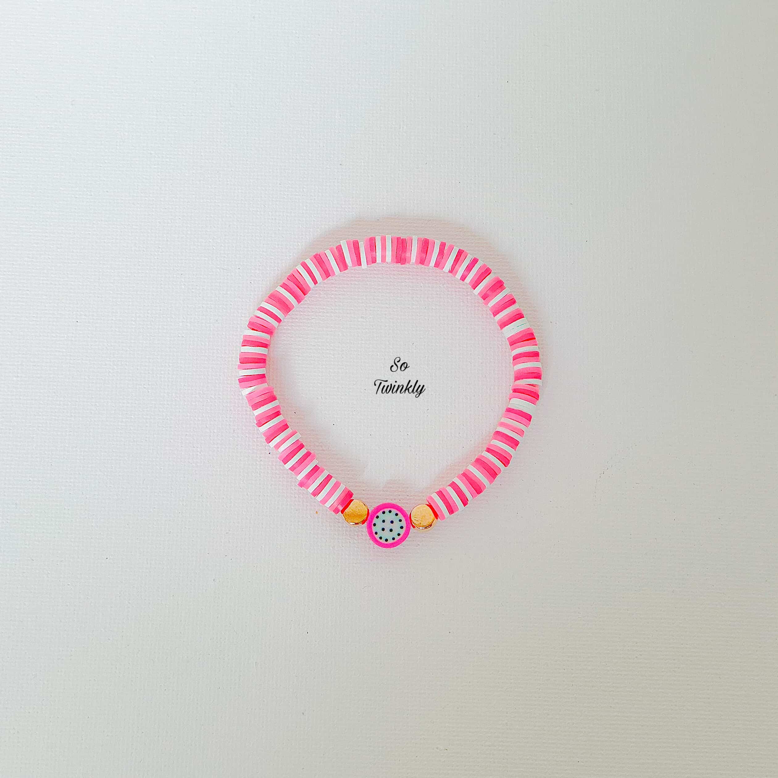 Flat lay of pink melon bracelet featuring gold acrylic pearls and vibrant polymer clay beads
