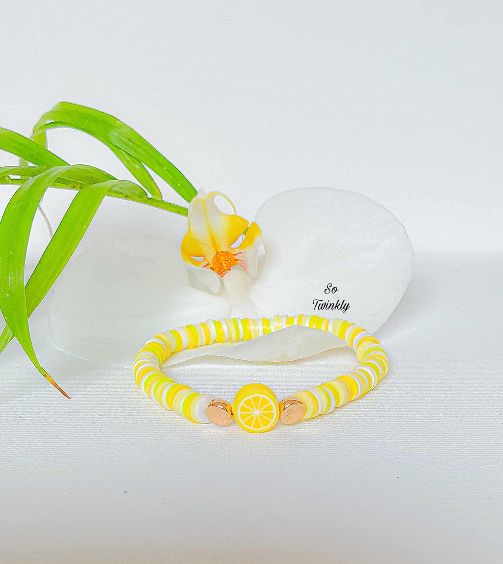 Handmade lemon bracelet with yellow, white, and neon beads and a lemon charm